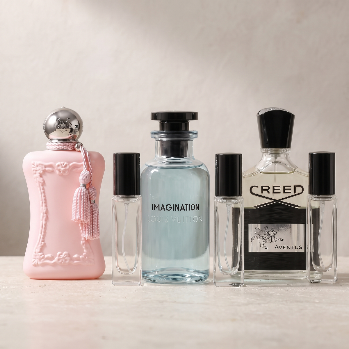 Parfums de Marly Delina, Louis Vuitton Imagination and Creed Aventus bottles with empty sample atomisers